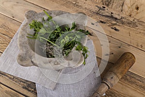 Herbs in stone mortar with wooden pestle