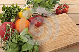 Herbs and vegetables with a blank chopping board