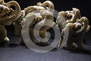 Herd of white-patterned elephants. Side shot. Black Background