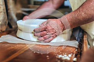 Herdsman`s hands during the preparation of cheeses otypical of northern Italy