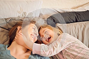 Here comes the tickle monster. Shot of a mother and her little girl lying in bed together at home.