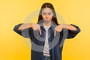 Here and right now! Portrait of girl in denim shirt pointing fingers down, ordering and controlling, demanding result