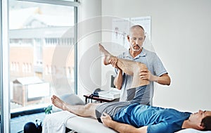 Here to help get rid of your aches and pains. a physiotherapist treating a patient.