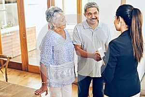 Here to help make your golden years the best years. a mature couple meeting with their financial consultant at home.