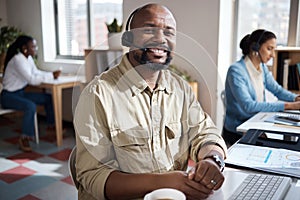 Always here to help. a mature businessman using a headset in a modern office with his colleague working in the
