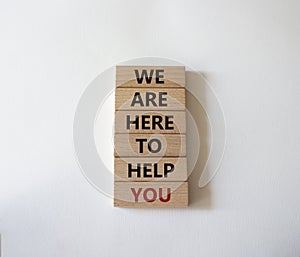 We are here to help you symbol. Concept words we are here to help you on wooden blocks. Beautiful white background. Business and
