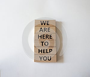 We are here to help you symbol. Concept words we are here to help you on wooden blocks. Beautiful white background. Business and