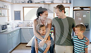 Heres a happy family for you. two affectionate young parents spending time with their kids in the kitchen at home.