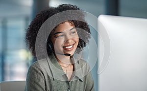 Heres looking at you. a young female agent smiling while working in a call centre.