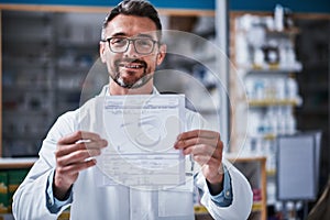 Heres my recommendation. Portrait of a mature pharmacist holding a page in a pharmacy.