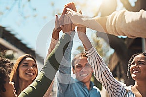 Heres to a awesome day ahead of us. a group of cheerful young friends forming a huddle and giving each other a high five