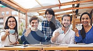 Heres to a successful business meeting. Portrait of a cheerful creative business team having a meeting and drinking