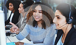 Heres what to do when the next call comes through...a young woman assisting her colleague in a call centre.