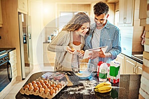 Heres your next instruction. a young couple mixing ingredients in their kitchen.