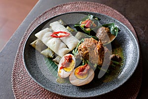 Heritage culture dish `Topot` specialty from Peliatan village Ubud,Bali, arrange in stone plate, on table, soft lighting.