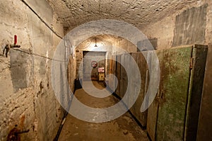 Hermetic rusty door of the bunker in underground abandoned tunnel. Mysterious old iron gate. Secret entrance