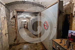 Hermetic rusty door of the bunker in underground abandoned tunnel. Mysterious old iron gate. Secret entrance