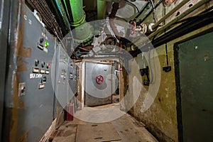 Hermetic rusty door of the bunker in underground abandoned tunnel. Mysterious old iron gate. Secret entrance