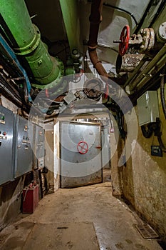 Hermetic rusty door of the bunker in underground abandoned tunnel. Mysterious old iron gate. Secret entrance