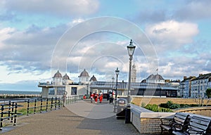 Herne bay promenade with people dressed as father Christmas walking along it and a sculpture of Amy Johnson .