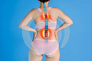 Hernia of the cervical spine, neck pain, woman suffering from ache on blue background, compression injury of the intervertebral