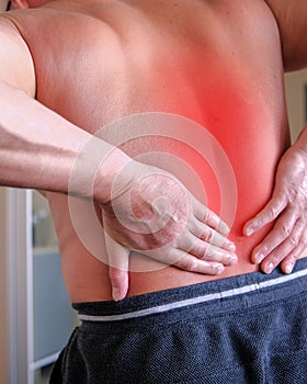 Hernia of the lumbar spine, a man with back pain at home, compression injury of the intervertebral disc in the lower