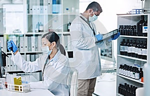 Heroes in labcoats. two young researchers working in a laboratory.