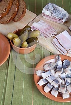 Herring, bread, pickles and bacon on a green napkin