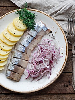 Herring fish with potatoes slices and red onion