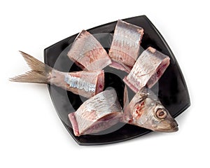 Herring pieces on black plate