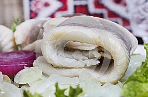 Herring rolls on onion and fresh lettuce