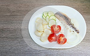 herring salad with vegetables on white plate top view
