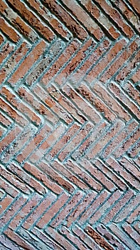 Herringbone brick pattern wall with cement pointing. Multiple rows.