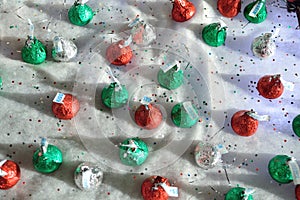Hershey`s Christmas Candy Kisses scattered in a cotton glitter background overhead view