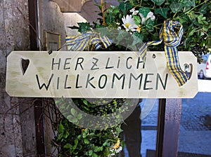 Herzlich willkommen sign translates into Welcome in English
