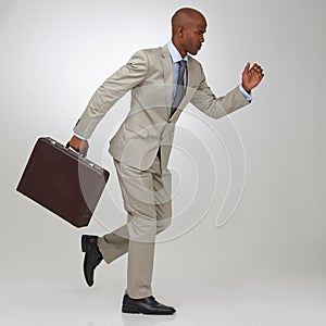 Hes ahead of the competition. An African-American businessman running with his briefcase.