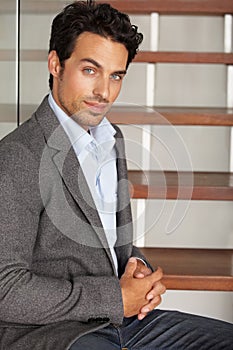 Hes a confident businessman. Portrait of a handsome young executive sitting on a staircase.