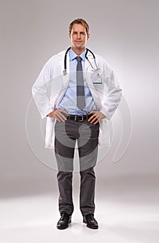 Hes confident he can cure you. Full length shot of a young doctor standing with his hands on his hips.