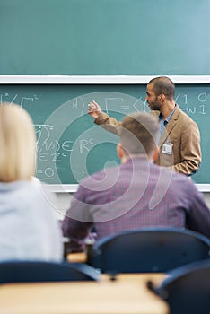 Hes dedicated to his students. a college professor giving a lesson to his students in the lecture hall.