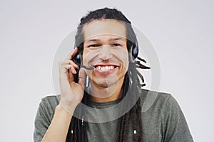 Hes dedicated to the job. Studio portrait of a handsome young male customer service representative wearing a headset