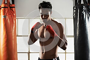 Hes dedicated to the sport of boxing. a young male boxer in a fighting stance.