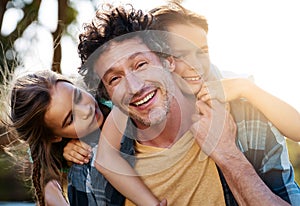 Hes doing a great job raising his kids. Portrait of a happy father spending time with his son and daughter outdoors.