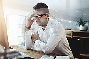 Hes faced one too many challenges for the day. a young businessman looking stressed out and tired while working in an