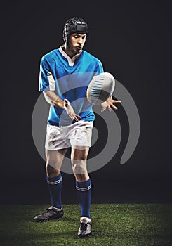 Hes a fierce competitor. Full length studio shot of a young rugby player on the field.