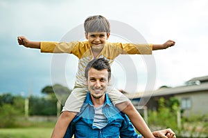 Hes flying high with his poppa. Portrait of a cheerful father carrying his young son on his shoulders outdoors. photo