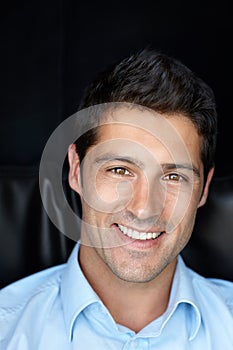 Hes a gorgeous guy. Cropped portrait of a young man smiling brightly against a black background.