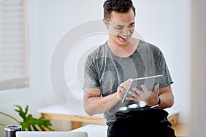 Hes got a knack for being innovative. a young businessman using a digital tablet in an office.