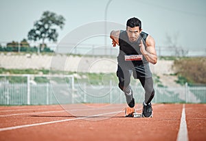 Hes got a need for speed. Full length shot of a handsome young male athlete running on an outdoor track.