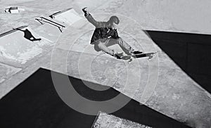 Hes got skill. A black and white shot of a skateboarder doing tricks at a skatepark.