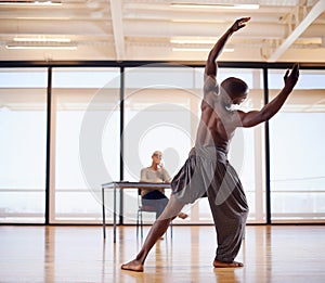 Hes got talent. Rearview shot of a male dancer performing before a judge during an audition.